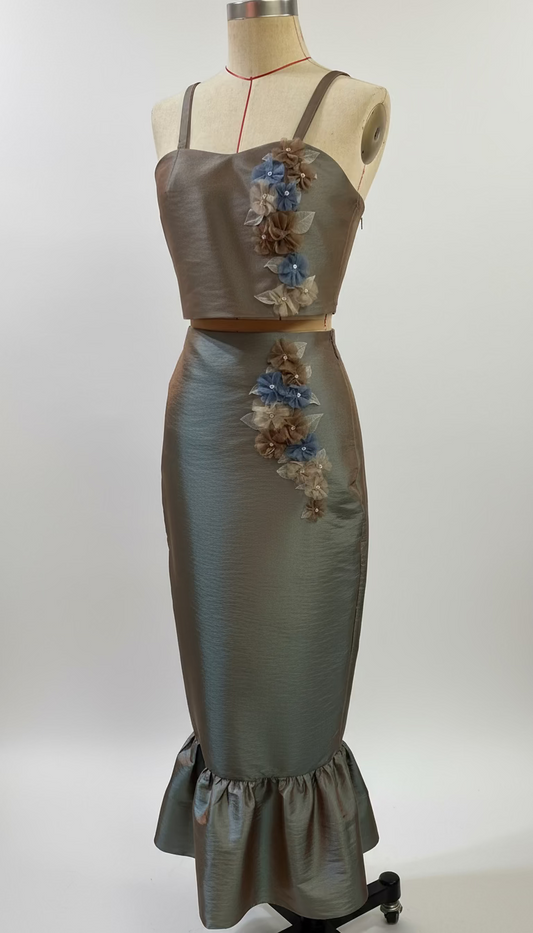 Satin dress with floral embellishments on a mannequin against a gray background