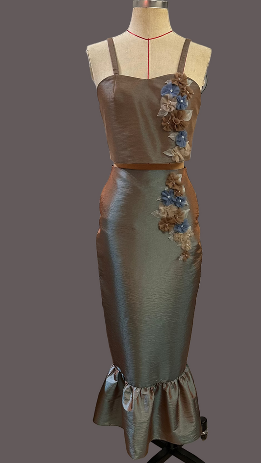 Satin dress with floral embellishments on a mannequin against a gray background